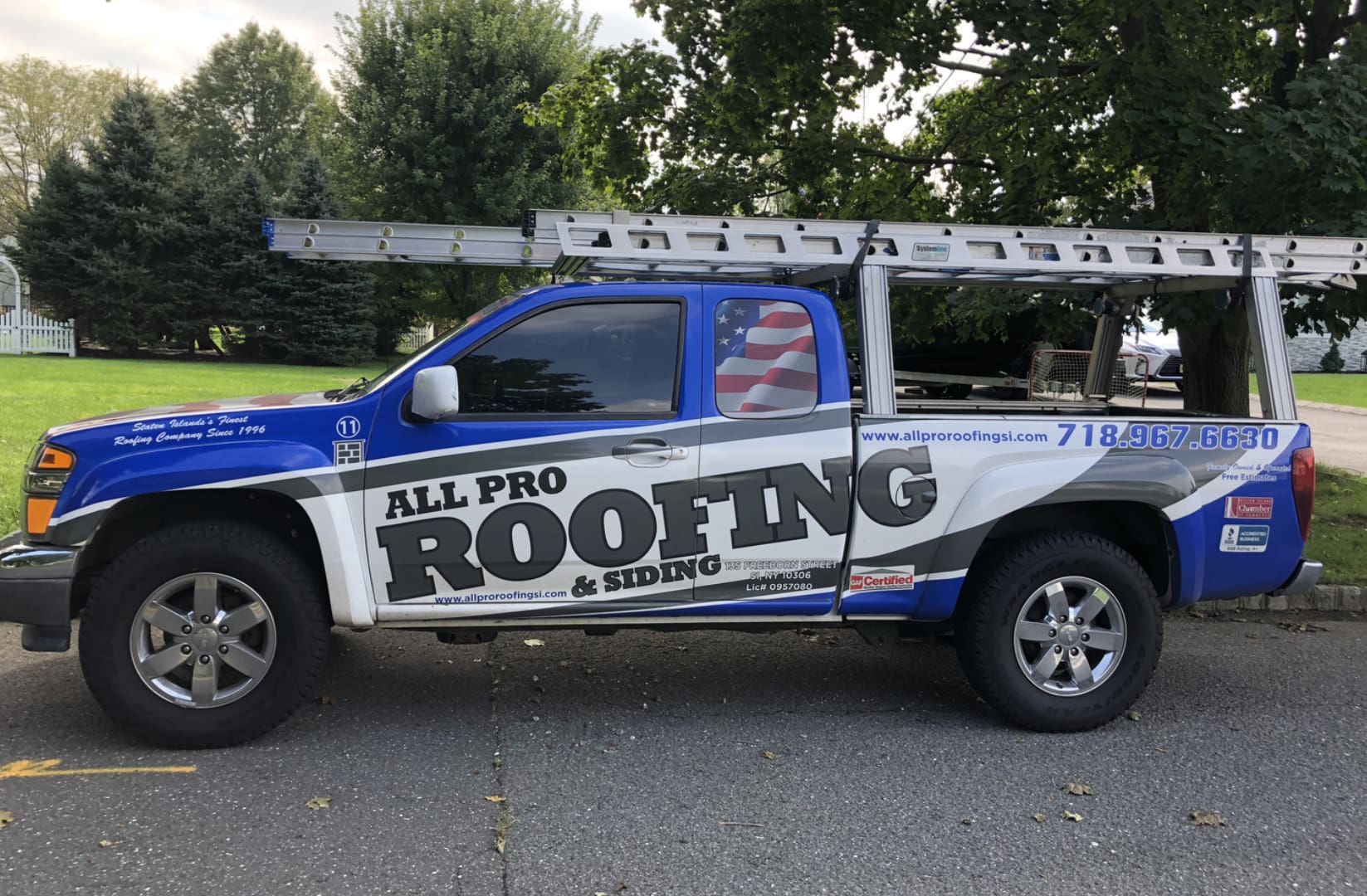 A blue truck with the words " all pro roofing & siding ".