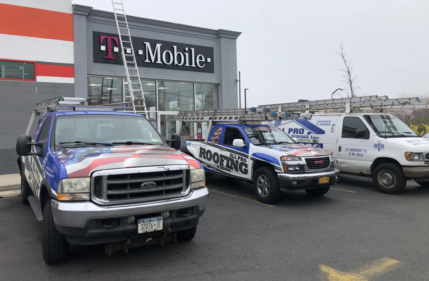 A group of trucks parked in front of a t-mobile store.