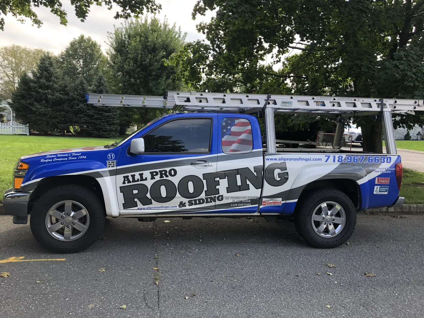 A blue truck with the words " all pro roofing & repairs ".