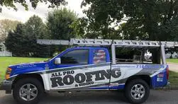 A blue truck with the words " all pro roofing & siding ".